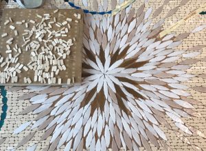 Mathilde Jonquière, mosaic artist, June 2019, Triptyque Céleste. The mosaic is composed of tesserae sparkling from radiant and deep golden brass colors to more neutral tones (linen, sand and umber) symbolizing the background canvas of the tapestry ready to be embroidered.