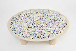 Mathilde Jonquière, mosaic artist, January 2023, original creation of a picassiette style table for Petit H, diameter 120cm. A heart made of gold tesserae that attracts the eye like a breath of fresh air, then these tesserae disappear little by little like pebbles thrown and sealed.