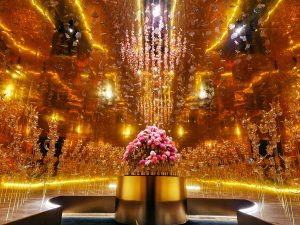 William Amor, upcycling artist, “Theater of Metamorphosis” art installation for the Lancôme exhibition, Shanghai, dimensions 700cm x 500cm x 500cm, December 2023. The rose-gold tulip field at the entrance, made from recycled bottles, seems to extend infinitely into the reflection of the mirrors.