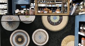 Mathilde Jonquière, artiste mosaïste, septembre 2019, La Petite Grande Épicerie de Paris, gare Saint-Lazare. Les architectes demandent à Mathilde Jonquière de créer cette fois-ci une fresque en mosaïque pour le comptoir de ce petit espace de 25 m2 dans l’optique de garder une unité avec les deux autres magasins Rive Gauche de 3 400m2 et Rive Droite rue de Passy de 2800m2.