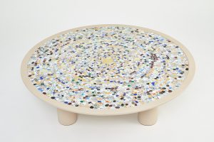 Mathilde Jonquière, artiste mosaïste, janvier 2023, création originale d’une table en picassiette pour Petit H, diamètre 130cm. Un centre composé de tesselles d’or qui attire le regard comme une aspiration puis ces tesselles disparaissent petit à petit comme des cailloux jetés puis scellés.